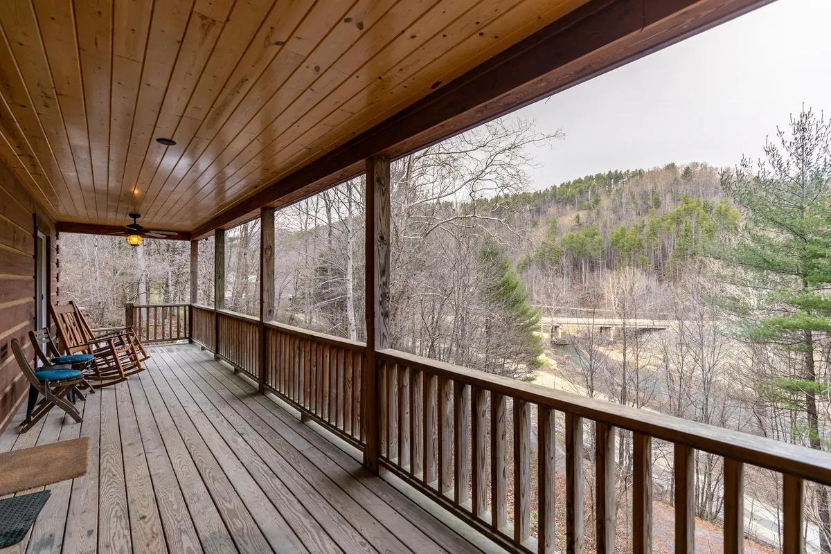 A spacious porch with classic wooden rocking chairs overlooks a sweeping natural landscape. The setting feels peaceful and inviting, perfect for unwinding after a day outdoors, with opportunities to enjoy sunrise views or quiet wildlife sightings.